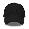 Claude Code Spinner Dad Hat - Actualizing - Black dad hat with orange embroidered text